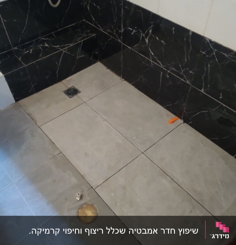 ריצוף חדש בחדר אמבטיה עם חיפוי קיר שחור